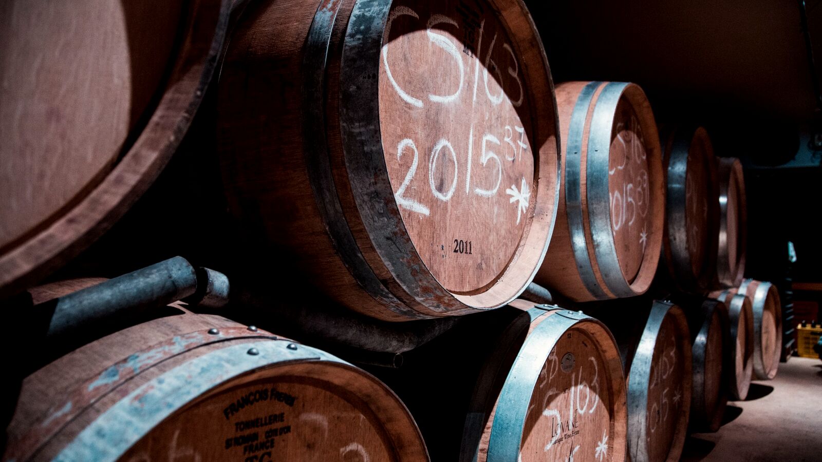 Oak wine barrels marked by hand with their vintages.